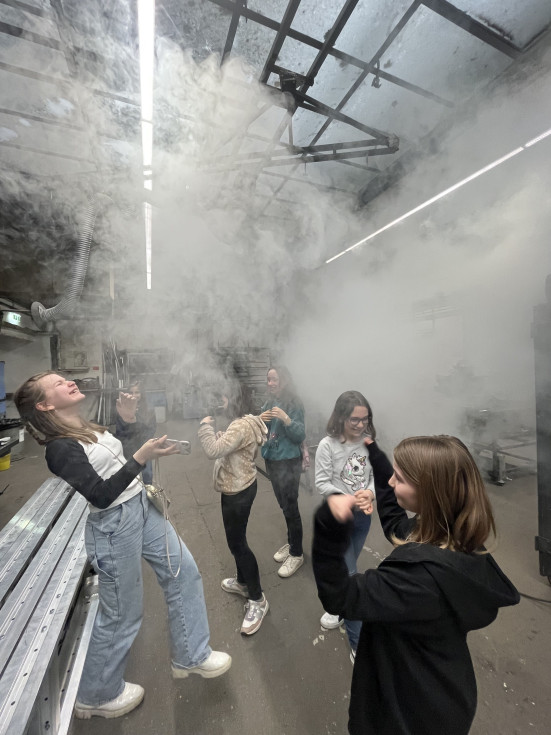 Teilnehmende des Töchtertages stehen in künstlich erzeugtem Nebel